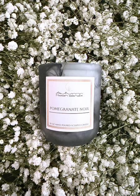 Autumn Moon Candle 10oz Pomegranate Noir Candle in a bed of flowers